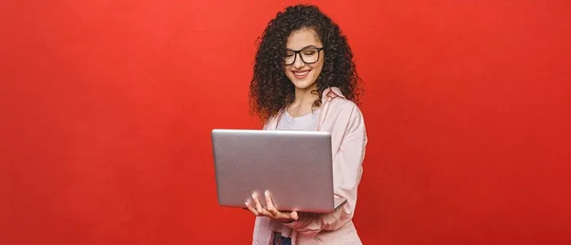 smiling woman with laptop red background